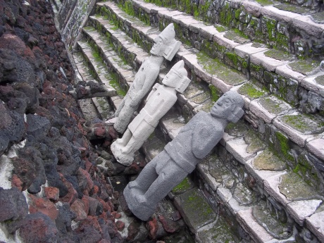 At the Templo Mayor, figures rest against steps of the pyramid.