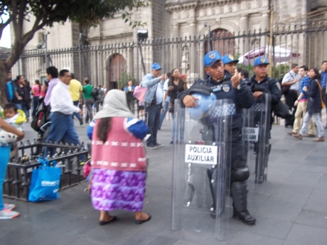 In front of the cathedral...Mexicans dressed for every occasion, in colorful indigenous skirt and vest, and bullet-proof vest 